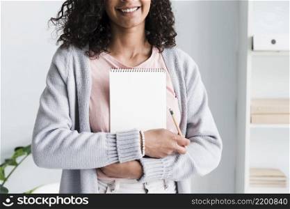 smiling young woman holding notebook workplace