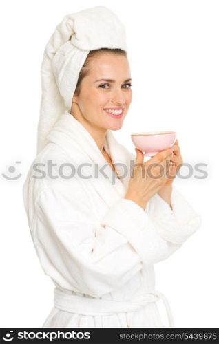 Smiling young woman in bathrobe with cup of tea