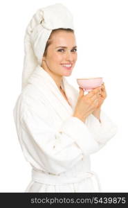 Smiling young woman in bathrobe with cup of tea