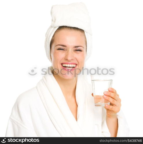 Smiling young woman in bathrobe with glass of water