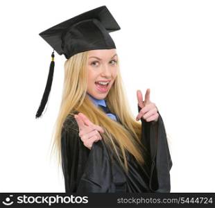 Smiling young woman in graduation gown pointing in camera
