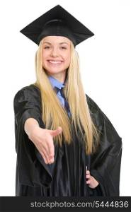 Smiling young woman in graduation gown stretching hand for handshake