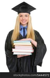 Smiling young woman in graduation gown with stack of books