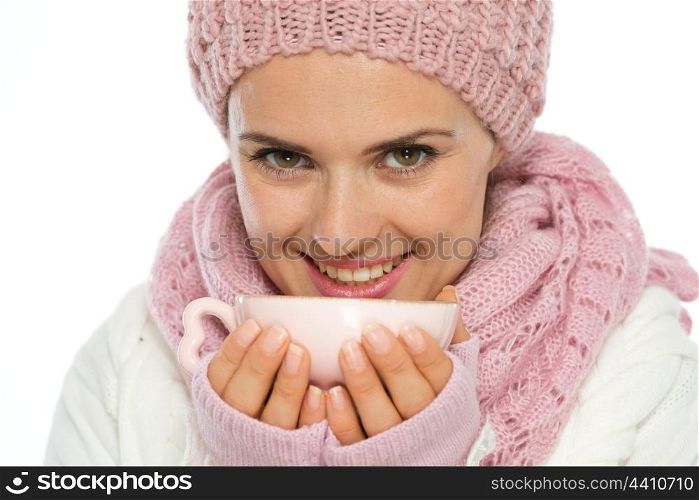 Smiling young woman in knit winter clothing holding cup of hot tea