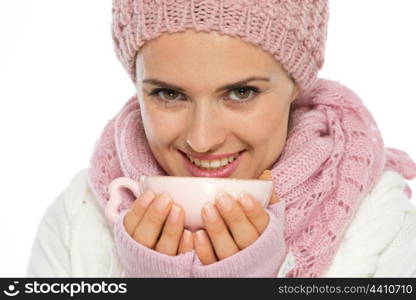 Smiling young woman in knit winter clothing holding cup of hot tea