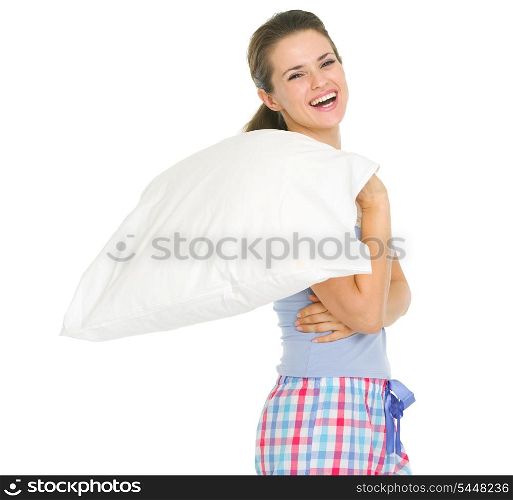 Smiling young woman in pajamas holding pillow
