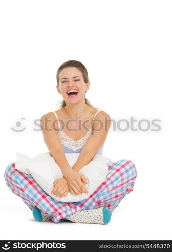 Smiling young woman in pajamas sitting with pillow