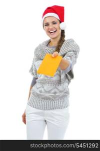 Smiling young woman in sweater and christmas hat giving letter
