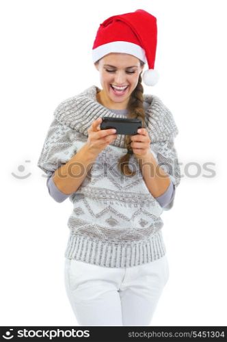 Smiling young woman in sweater and christmas hat reading sms