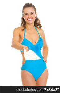 Smiling young woman in swimsuit giving air tickets