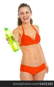 Smiling young woman in swimsuit giving bottle of water