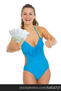 Smiling young woman in swimsuit showing fan of euros