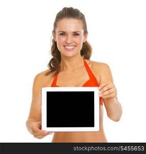 Smiling young woman in swimsuit showing tablet pc blank screen