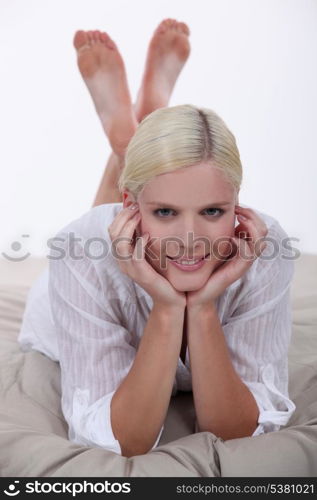 Smiling young woman lying on a bed