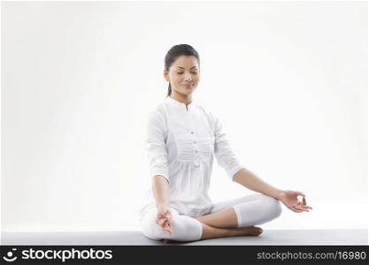 Smiling young woman meditating