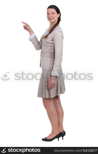 smiling young woman pointing at someone isolated on white