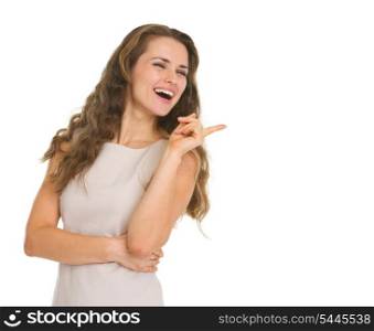 Smiling young woman pointing on copy space
