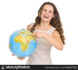 Smiling young woman pointing on globe