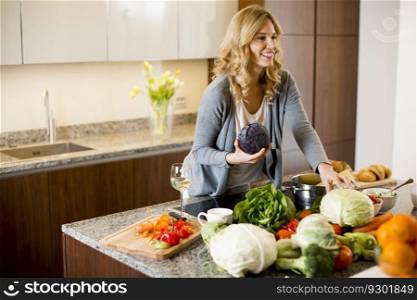 Smiling young woman preparing food in modern kitchen