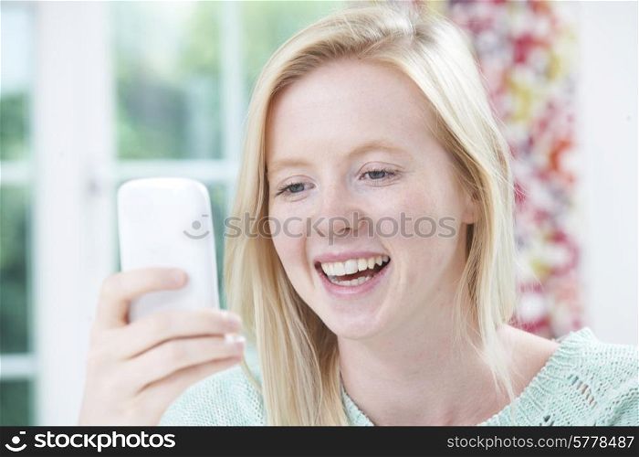 Smiling Young Woman Reading Text Message