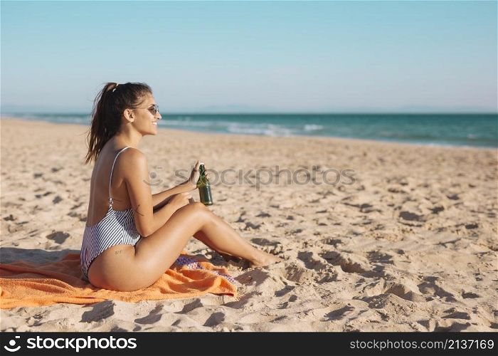 smiling young woman relaxing beach with beer
