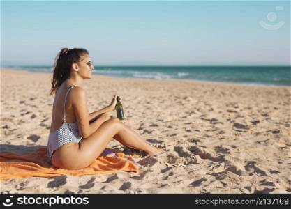 smiling young woman relaxing beach with beer