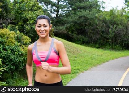 Smiling young woman running for fitness