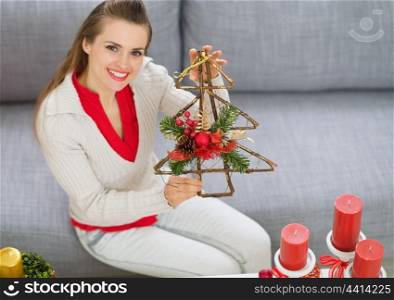 Smiling young woman showing Christmas decorations