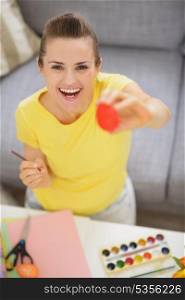 Smiling young woman showing Easter red egg