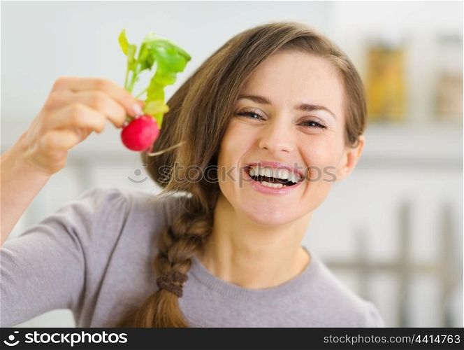 Smiling young woman showing radish