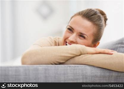 Smiling young woman sitting on couch