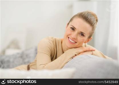Smiling young woman sitting on couch in living room