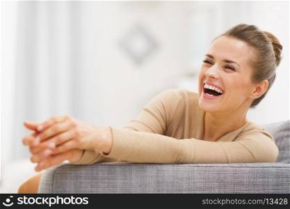 Smiling young woman sitting on sofa