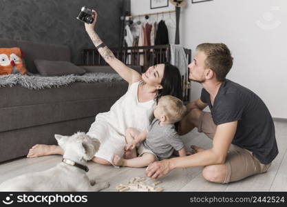 smiling young woman taking selfie her family while sitting living room