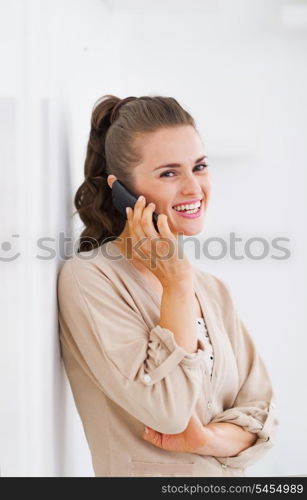 Smiling young woman talking cell phone