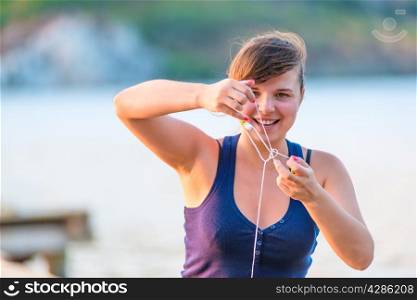 smiling young woman unravels headphones
