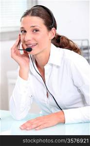 Smiling young woman using a headset