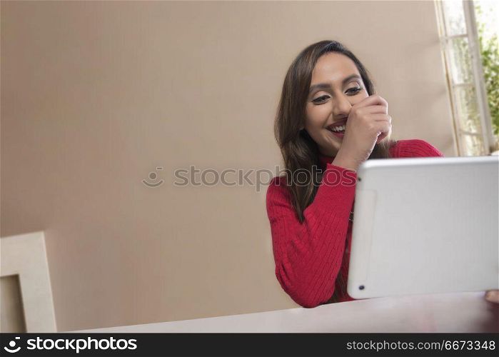 Smiling young woman using digital tablet