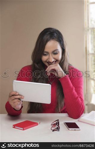 Smiling young woman using digital tablet