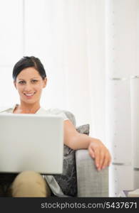 Smiling young woman using laptop