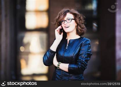 Smiling young woman using mobile smartphone on the street