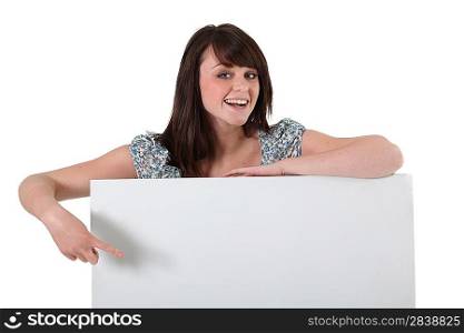 Smiling young woman with a board left blank for your message