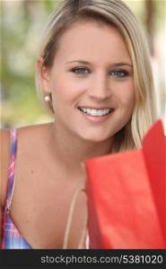 Smiling young woman with a store bag