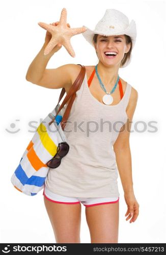 Smiling young woman with beach bag showing starfish