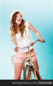 Smiling young woman with bike bicycle. Fashionable girl in hat, white shirt and shorts. Summer fashion and recreation. Studio shot.
