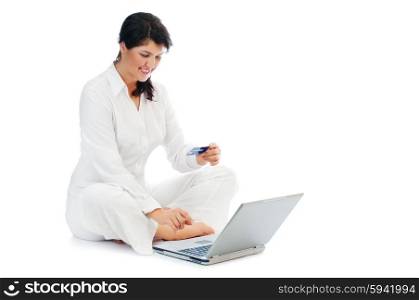 Smiling young woman with credit card and laptop isolated