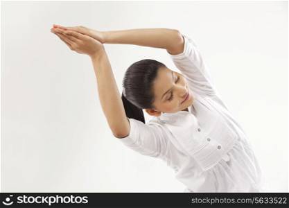 Smiling young woman with hands clasped doing yoga