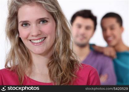 Smiling young woman with lads in the background