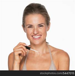 Smiling young woman with lip gloss