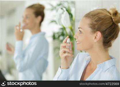 smiling young woman with perfum bottle